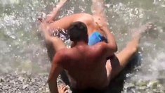 Girl sucks dick her boyfriend in the surf at a public beach